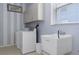 Bright laundry room features a washer, dryer, and utility sink with ample storage space at 4215 Maplehurst Way, Spring Hill, FL 34609