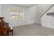 Open-concept living area with neutral tones, large window and stairway at 4215 Maplehurst Way, Spring Hill, FL 34609
