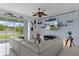 Spacious living room with a large sectional sofa, a ceiling fan, and a view of the backyard at 4215 Maplehurst Way, Spring Hill, FL 34609
