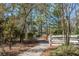 Tree-lined community walking path with manicured landscaping and white wooden gate at 4215 Maplehurst Way, Spring Hill, FL 34609