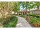 Charming walkway lined with lush landscaping leading to a building's entrance, creating an inviting approach at 4215 Maplehurst Way, Spring Hill, FL 34609