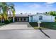 Charming single-story home featuring a covered carport, palm trees, and a well-maintained front yard at 4221 San Rafael Ave, New Port Richey, FL 34655