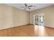 Bright living room features wood floors, a ceiling fan, and sliding doors to the screened patio at 4221 San Rafael Ave, New Port Richey, FL 34655
