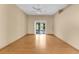Large living room features wood floors, a ceiling fan, and sliding doors to a screened patio at 4221 San Rafael Ave, New Port Richey, FL 34655