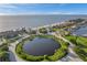 Stunning aerial view of waterfront homes, a beach, and a picturesque community lake, all under a clear blue sky at 4468 Rudder Way, New Port Richey, FL 34652
