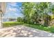 Spacious backyard with a concrete patio, lush green grass and mature trees. Pool in background at 4468 Rudder Way, New Port Richey, FL 34652