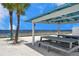 Beach cabana on the sand, providing a relaxing retreat with picnic tables and palm trees at 4468 Rudder Way, New Port Richey, FL 34652