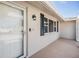Inviting front porch featuring a storm door, black sconce, and freshly painted walls at 4468 Rudder Way, New Port Richey, FL 34652