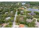 An aerial view captures the home, nestled within a leafy neighborhood near a serene lake at 4595 Lake In The Woods Dr, Spring Hill, FL 34607