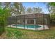 Beautifully landscaped backyard with a screened in pool and covered patio at 4595 Lake In The Woods Dr, Spring Hill, FL 34607