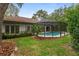 Backyard view showcasing the screened pool, lush landscaping and privacy at 4595 Lake In The Woods Dr, Spring Hill, FL 34607