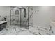 Modern bathroom featuring marble tiling, glass shower, and a soaking tub at 4595 Lake In The Woods Dr, Spring Hill, FL 34607