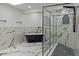 Stunning bathroom featuring a sleek black tub, marble floors, and a modern glass-enclosed shower at 4595 Lake In The Woods Dr, Spring Hill, FL 34607