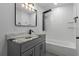 Modern bathroom with a gray vanity, tiled shower, and tub at 4595 Lake In The Woods Dr, Spring Hill, FL 34607
