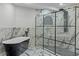 Luxurious bathroom boasts marble walls, a black bathtub, and a frameless glass shower with a rainfall showerhead at 4595 Lake In The Woods Dr, Spring Hill, FL 34607