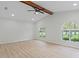 Inviting bedroom with vaulted ceilings, wood beam, light wood floors, and arched windows for natural light at 4595 Lake In The Woods Dr, Spring Hill, FL 34607