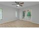 Neutral bedroom with wood-look floors and sliding glass doors to patio at 4595 Lake In The Woods Dr, Spring Hill, FL 34607