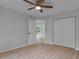 A bright bedroom features wood-look floors, a ceiling fan, and a closet at 4595 Lake In The Woods Dr, Spring Hill, FL 34607