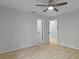 Neutral bedroom with wood-look floors, a ceiling fan, and doorway at 4595 Lake In The Woods Dr, Spring Hill, FL 34607