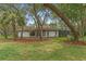 Well-maintained single-story home featuring mature trees and a large yard at 4595 Lake In The Woods Dr, Spring Hill, FL 34607