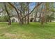 This property boasts a well-maintained lawn, mature trees, and attractive architectural details at 4595 Lake In The Woods Dr, Spring Hill, FL 34607