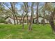 Charming home with mature trees, a well-maintained lawn, and unique architectural features at 4595 Lake In The Woods Dr, Spring Hill, FL 34607