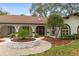 Charming home featuring arched entryways, beautiful landscaping, and a welcoming facade at 4595 Lake In The Woods Dr, Spring Hill, FL 34607