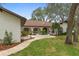 Inviting home entrance with lush landscaping, a circular driveway, arched entryways, and a charming facade at 4595 Lake In The Woods Dr, Spring Hill, FL 34607
