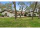 Beautiful home with mature trees, a well-kept lawn, and unique architectural details at 4595 Lake In The Woods Dr, Spring Hill, FL 34607