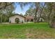 Charming home featuring a well-manicured lawn, a circular driveway, and a unique architectural design at 4595 Lake In The Woods Dr, Spring Hill, FL 34607