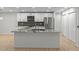 Modern kitchen features a granite countertop island, stainless steel appliances, and stylish backsplash at 4595 Lake In The Woods Dr, Spring Hill, FL 34607