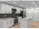 Modern kitchen with white cabinets, granite countertops, stainless steel appliances, and center island at 4595 Lake In The Woods Dr, Spring Hill, FL 34607