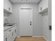Laundry room with white cabinets, granite counters, and wood-look floors at 4595 Lake In The Woods Dr, Spring Hill, FL 34607