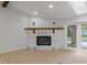 Cozy living room featuring a stone fireplace, wood mantel, and sliding glass doors to the pool at 4595 Lake In The Woods Dr, Spring Hill, FL 34607