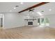 Large living room with stone fireplace, a wood beam, skylight, and sliding glass doors at 4595 Lake In The Woods Dr, Spring Hill, FL 34607