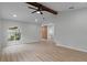 Open concept living room with light wood floors, vaulted ceilings with wood beam, and arched windows at 4595 Lake In The Woods Dr, Spring Hill, FL 34607