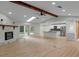 Open floor plan with stone fireplace, wood beam, and a view into the bright modern kitchen at 4595 Lake In The Woods Dr, Spring Hill, FL 34607