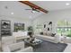 Elegant living room featuring vaulted ceilings, wood beam, arched windows, and stylish furnishings at 4595 Lake In The Woods Dr, Spring Hill, FL 34607