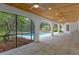 The covered outdoor living space offers tile flooring, arched entryways, and backyard views at 4595 Lake In The Woods Dr, Spring Hill, FL 34607