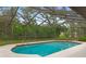 A beautiful screened-in pool is surrounded by lush landscaping at 4595 Lake In The Woods Dr, Spring Hill, FL 34607