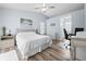 Bedroom features a ceiling fan, wood floors, beach themed artwork, and an adjacent work area at 5087 Oyster Ct, Spring Hill, FL 34607