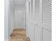 Hallway with wood floor and large closet with white louvered doors for ample storage at 5087 Oyster Ct, Spring Hill, FL 34607
