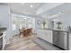 Modern kitchen with white cabinets, granite countertops, stainless steel appliances, and a dining area at 5087 Oyster Ct, Spring Hill, FL 34607