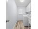 Well-lit laundry room with wood-look flooring and built-in cabinets above the washer and dryer at 5087 Oyster Ct, Spring Hill, FL 34607