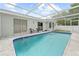 Inviting backyard pool features a screened-in enclosure and poolside seating area at 5087 Oyster Ct, Spring Hill, FL 34607