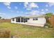 Exterior view of the home showcasing the screened patio and the backyard at 5642 Dove Dr, New Port Richey, FL 34652