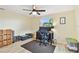 Bright bedroom featuring a ceiling fan, a workstation with dual monitors and natural light from the window at 5642 Dove Dr, New Port Richey, FL 34652