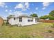 Exterior view of the home showcasing the backyard, windows, screened patio and lawn at 5642 Dove Dr, New Port Richey, FL 34652