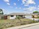 Single-story home featuring a well-manicured front yard with mature landscaping at 5642 Dove Dr, New Port Richey, FL 34652