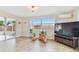Relaxing living area with a TV and sliding door leading to an enclosed patio with ample natural light at 5642 Dove Dr, New Port Richey, FL 34652